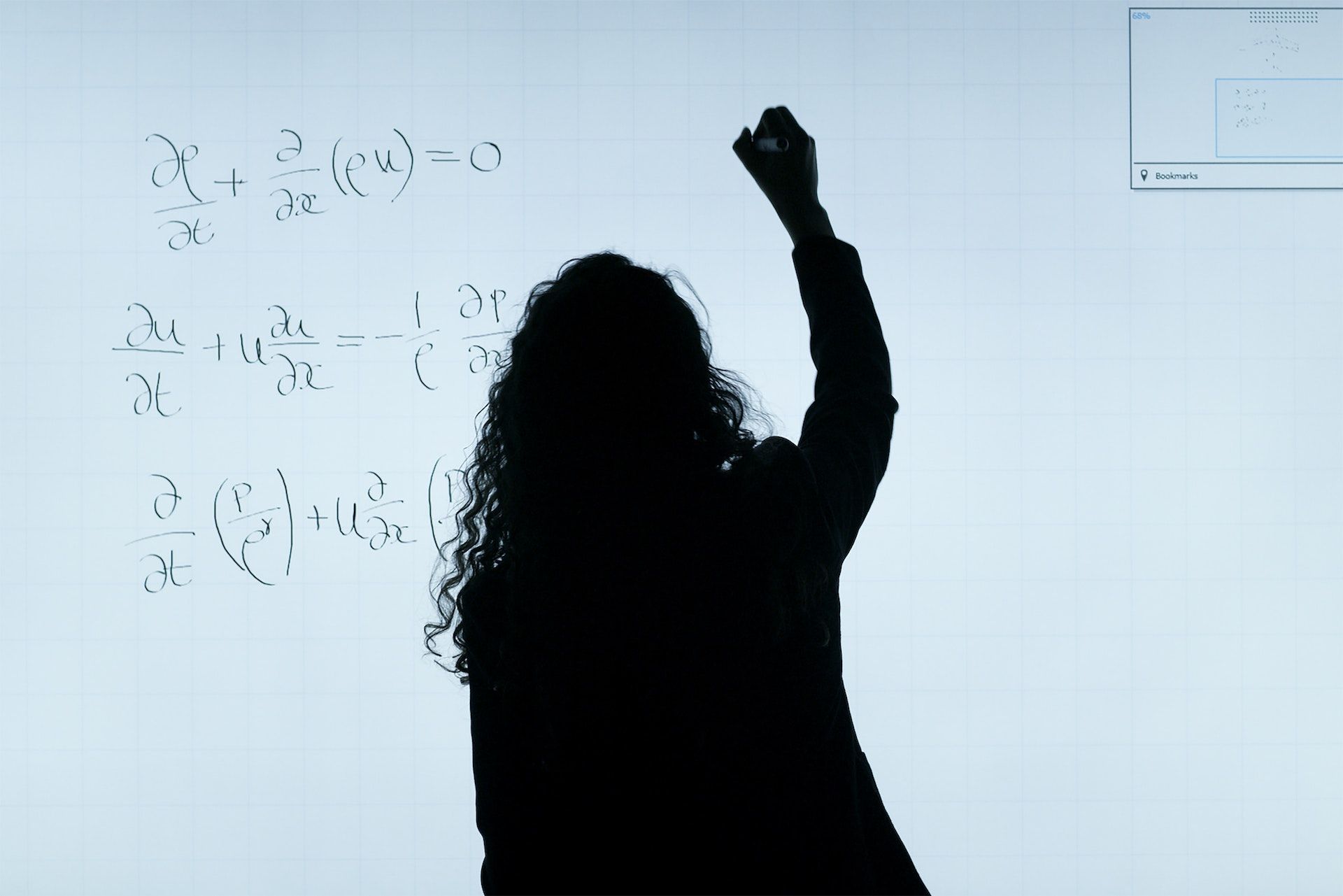 Student writing mathematical equations on a white board